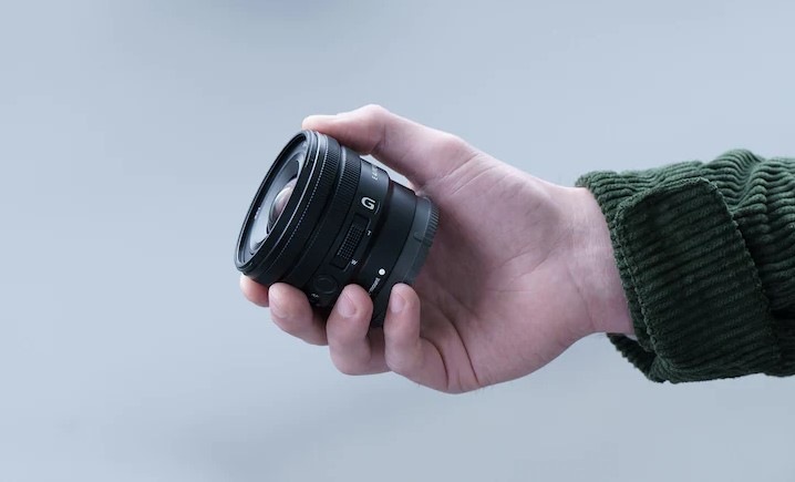 Snímek ruky člověka držícího objektiv E PZ 10-20mm F4 G, který je dost malý na to, aby se vešel do lidské ruky
