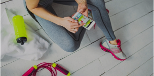 sedící žena ve sportovním oblečení s mobilem v ruce sedící žena ve sportovním oblečení s mobilem v ruce