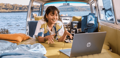 Dívka s notebookem HP v autě u jezera